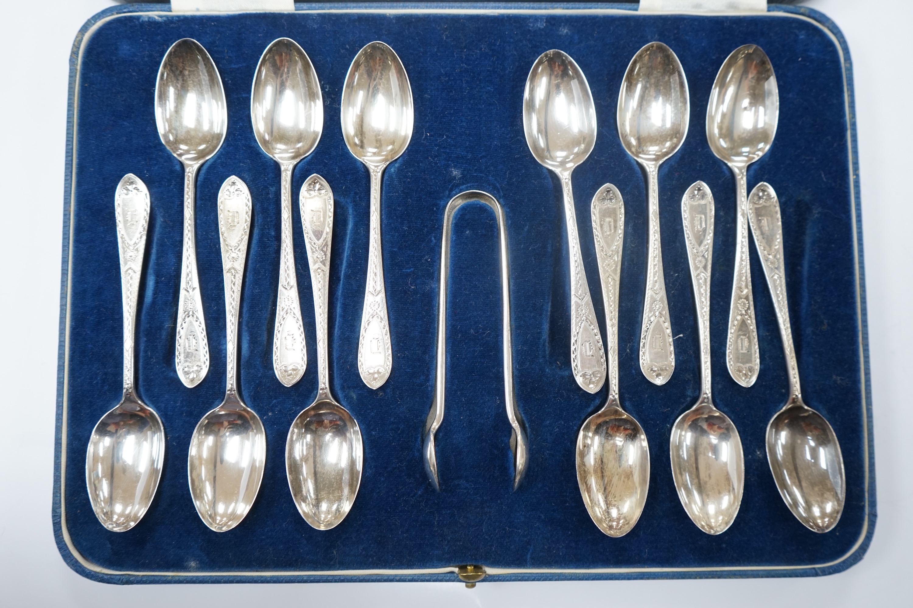 A cased set of twelve late Victorian silver bright cut engraved teaspoons and tongs, by Josiah Williams & Co, London, 1898, together with a silver locket and vesta case. Condition - fair to good